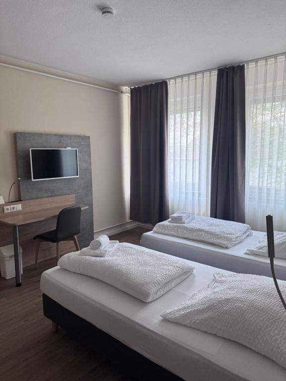a hotel room with two beds and a desk at Boardinghaus-net in Fulda