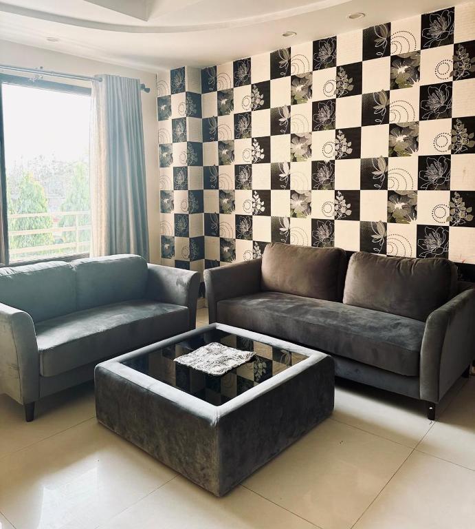 a living room with a couch and a coffee table at Hotel Asha in Kannauj