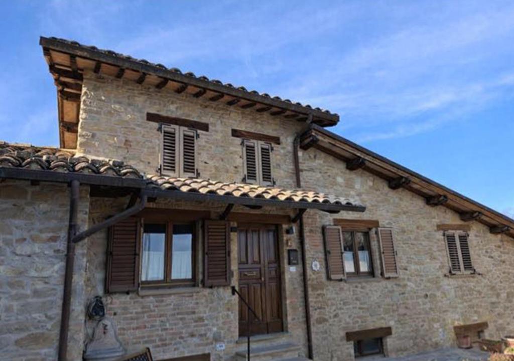 an old stone house with wooden doors and windows at Affittacamere Castelmanardo in Amandola