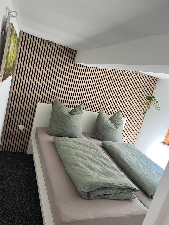 a bed with pillows on it in a bedroom at Fewo Kleine Gasse, super Zentral, Privat Parkplatz, in Ruhla