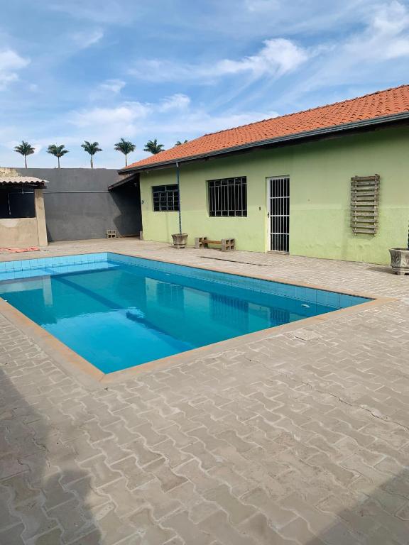a swimming pool in front of a building at Chácara do Neno in Limeira