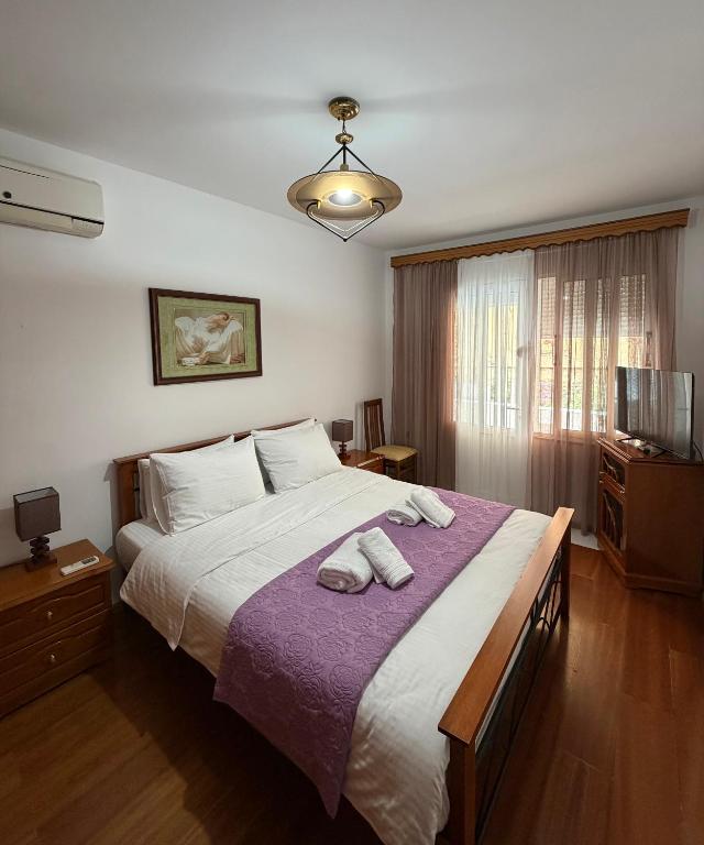 a bedroom with a large bed with two towels on it at Alex Guest Apartment in Gjirokastër