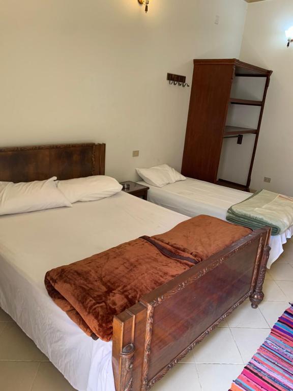 a bedroom with two beds with white sheets at Kabeel's House in Dahab