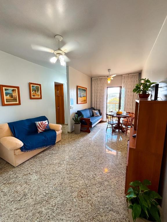 a living room with a blue couch and a table at Refugio do Forte Cabo Frio in Cabo Frio