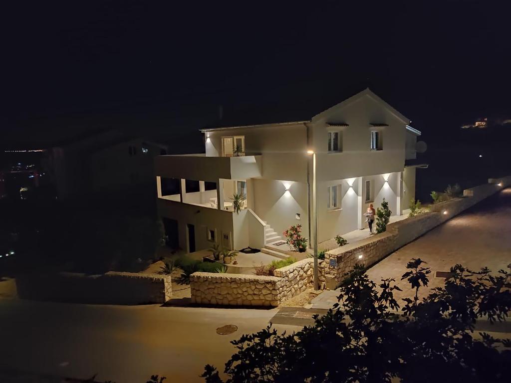 a white house at night with lights on it at Apartman Goga i Dragan in Drage