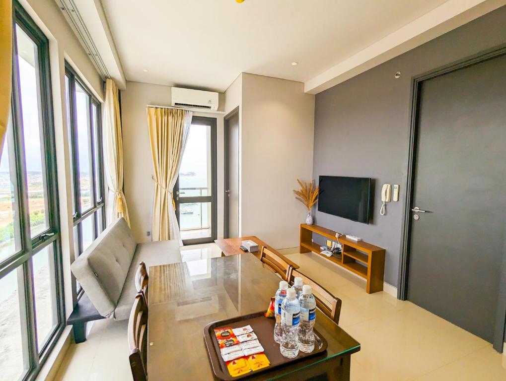 a living room with a table and a television at Lovina 21-AA at One Residence in Batam Center