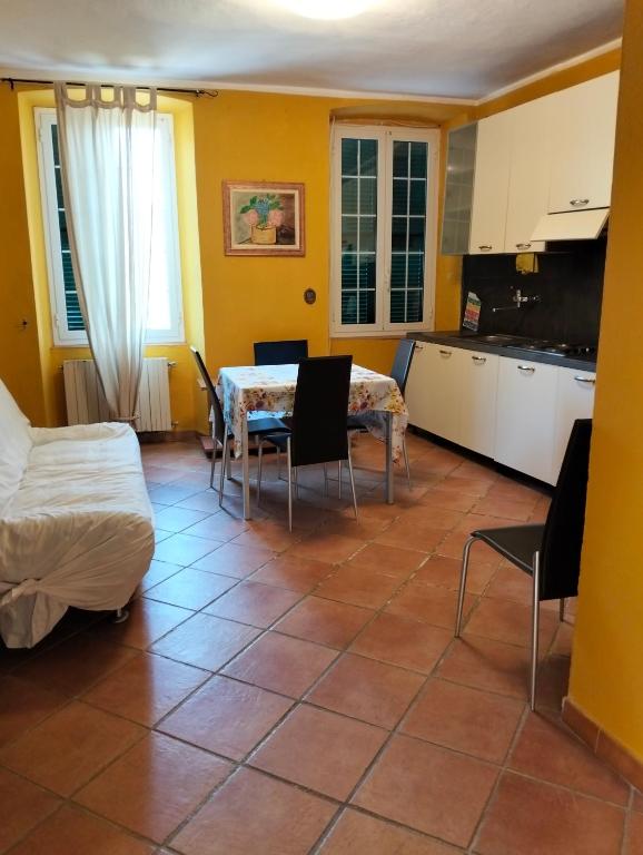 a living room with a table and chairs and a kitchen at Appartamento Ortensia in Montale