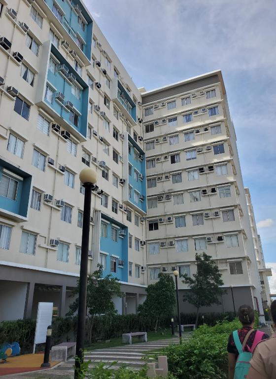 a tall building with people standing in front of it at MJ Luxury Living in Iloilo City