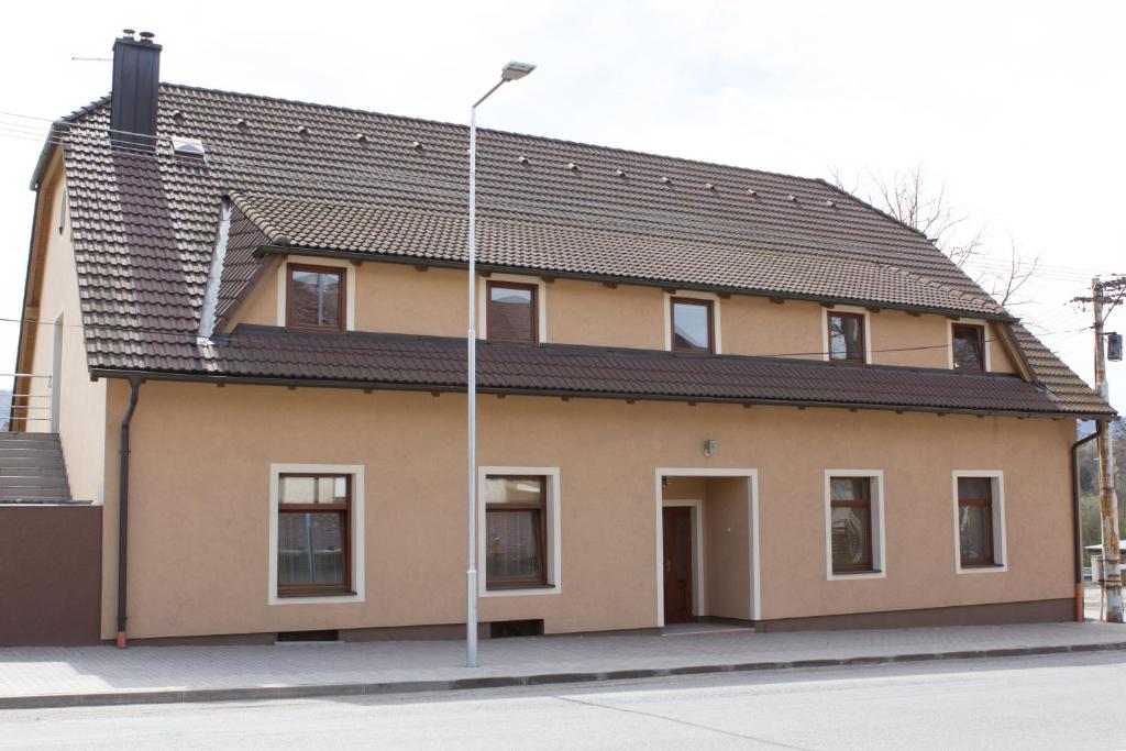 a house with a pitched roof and a street light at Penzion Leona in Obecnice