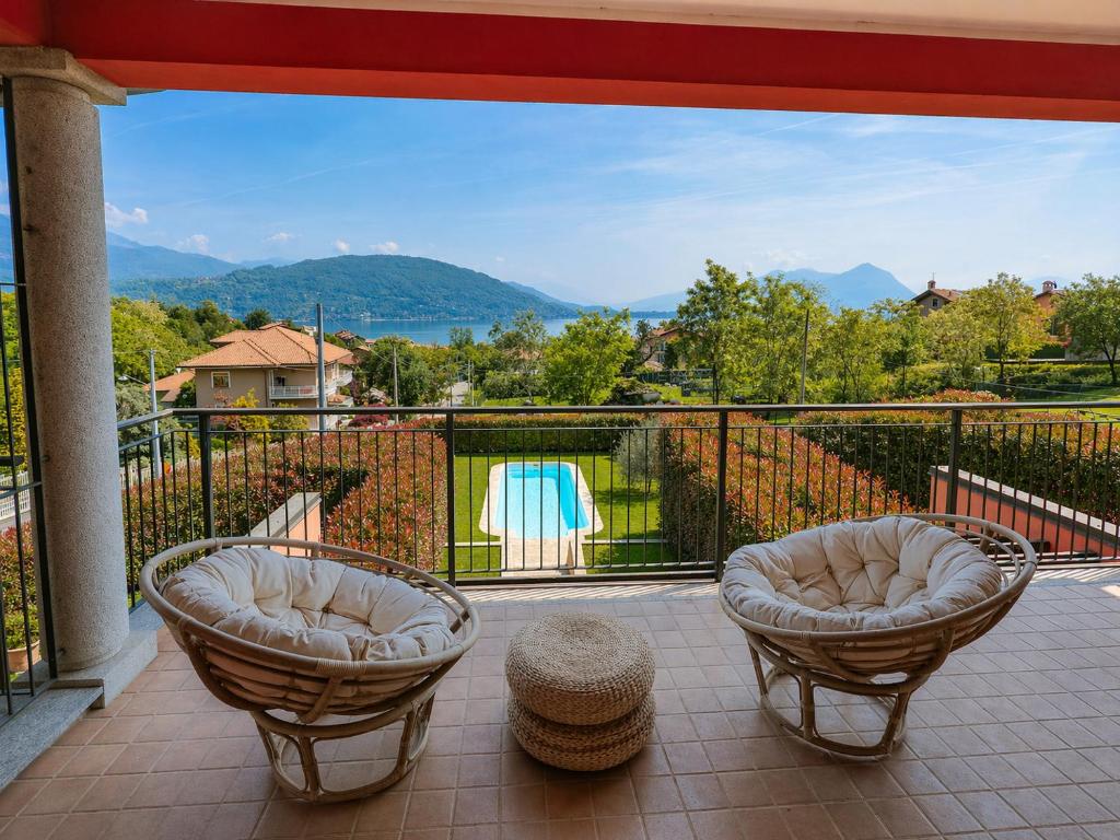 a balcony with two chairs and a view of the water at Villetta dei Pascoli in Baveno
