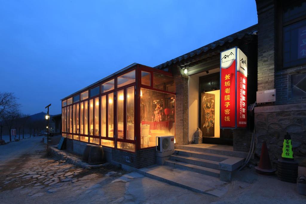 un edificio de cristal con luces en una calle en The Great Wall Courtyard Hostel, en Yanqing