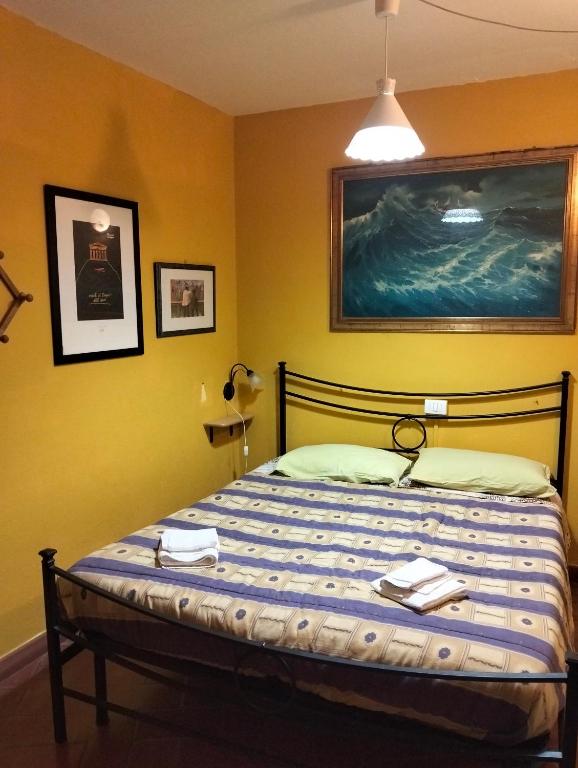 a bedroom with a bed with a painting on the wall at Appartamento il Giglio in Montale