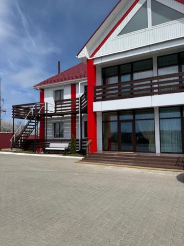 a red and white building with a staircase in front of it at Готель-ресторан Октан in Holovanivs'k