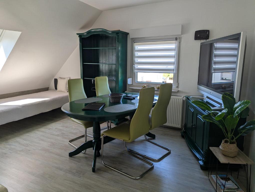 a dining room with a green table and chairs at Ferienwohnung Martin Wadgassen in Wadgassen