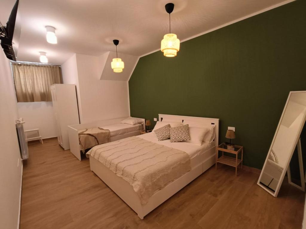 una camera da letto con due letti e una parete verde di Murorotto a Castello del Matese