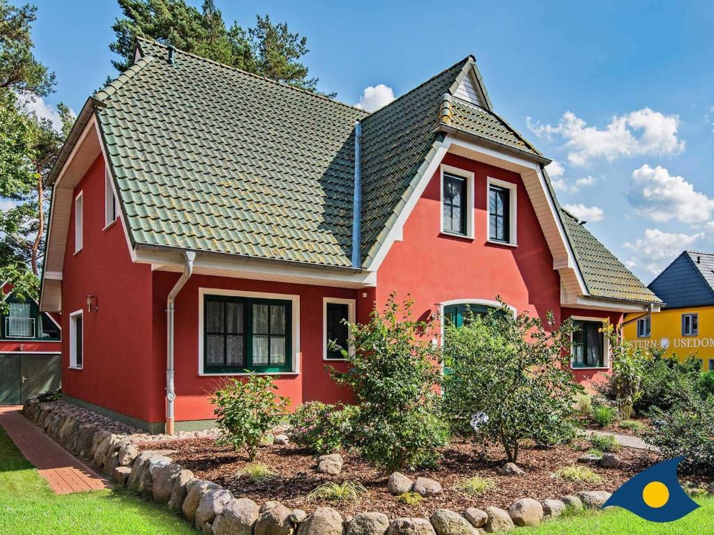 a red house with a black roof at Fraeulein Loddin Whg_ Hugo in Kölpinsee