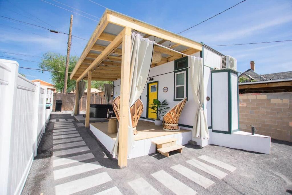 a small house with awning and a patio at The Frida Tiny House-Hot Tub-Pet Friendly-No Pet Fee! in Albuquerque