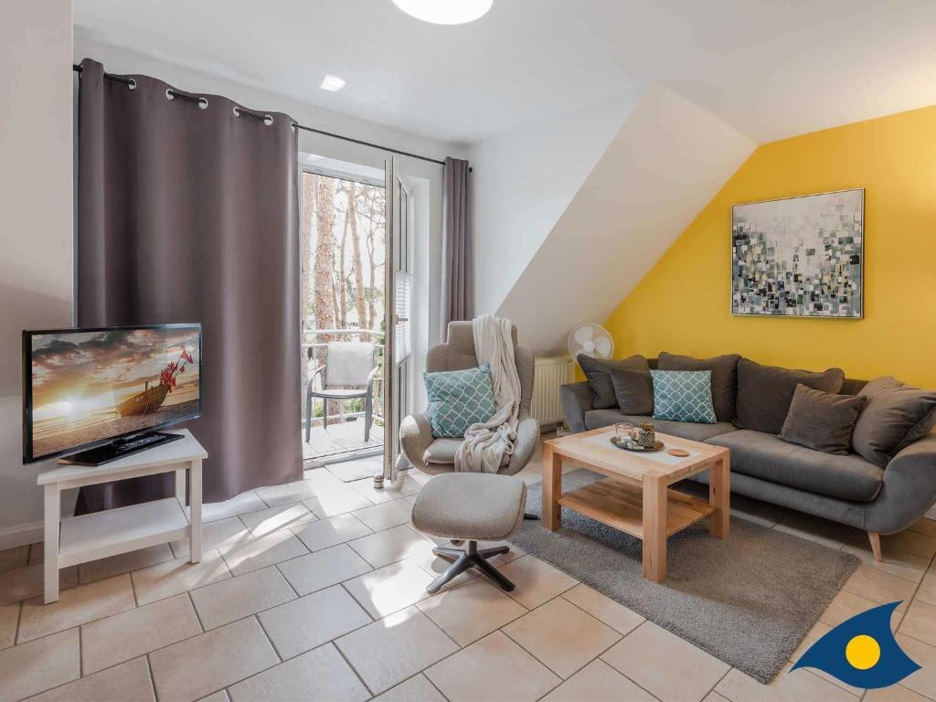 a living room with a couch and a tv at Fraeulein Loddin Whg_ Ole in Kölpinsee