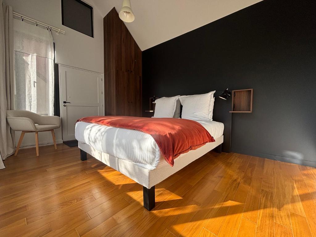 a bedroom with a bed with a red blanket on it at La Maison d'Amboise in Amboise