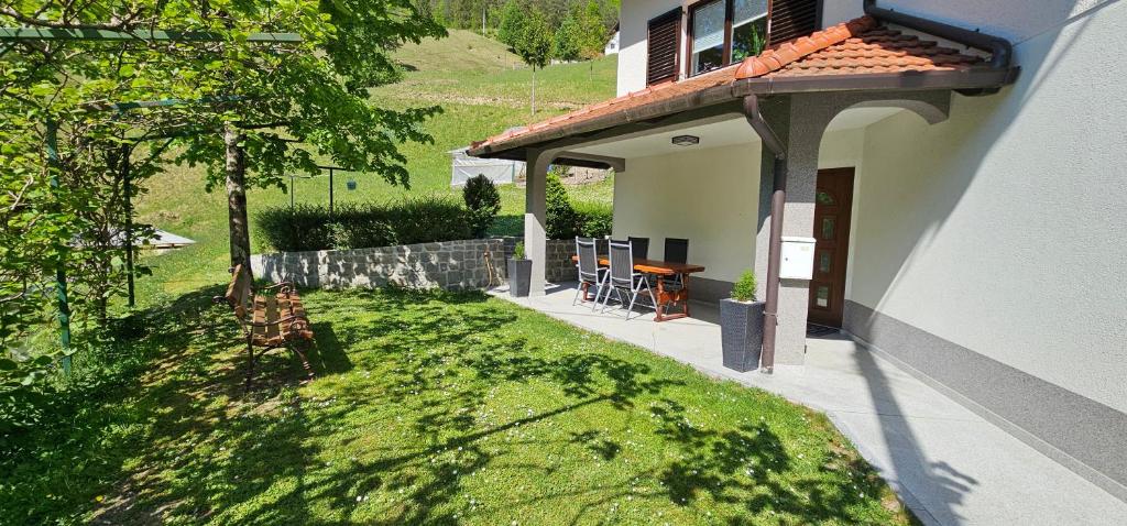 a house with a yard with a table and chairs at Apartma Šmarnica in Slap ob Idrijci
