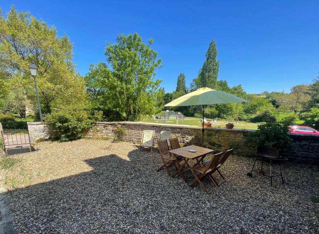 a table and chairs with a green umbrella at Gîte de l 'Angeline in Bissey-sous-Cruchaud