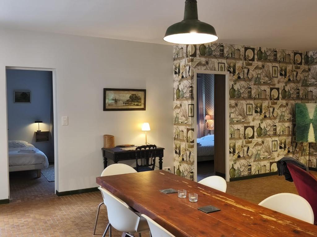 a dining room with a table and chairs and a bedroom at Aubrion de Cremens in Magnan