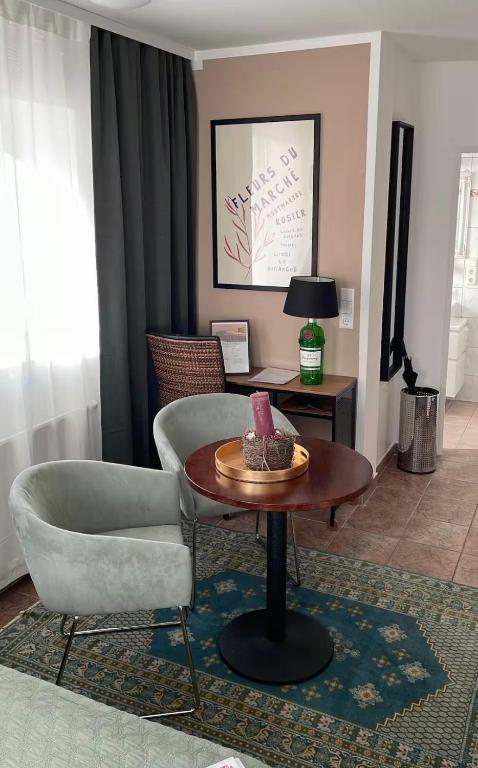 a living room with a table and a chair at Quartier am Fluss - CityNest in Innsbruck