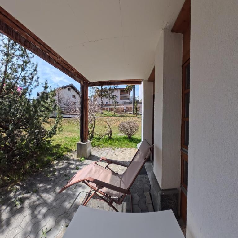 a patio with a chair and a view of a field at Alpen-Retreat mit Spa in Lenzerheide