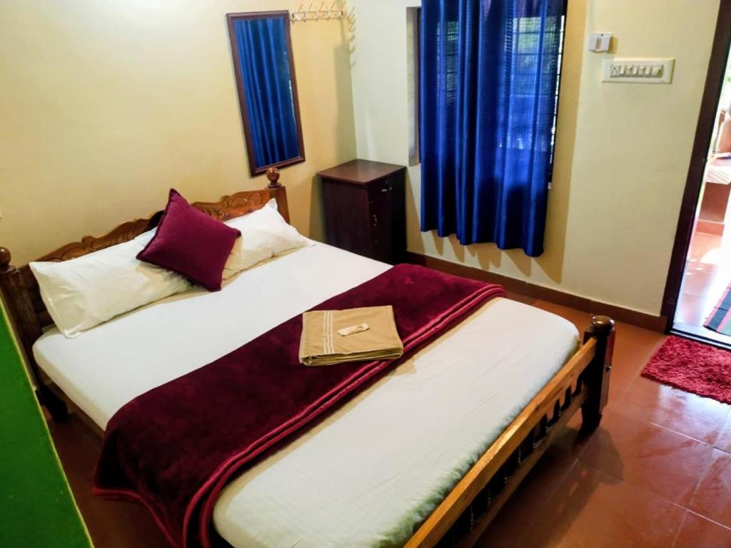 a bed with a purse sitting on top of it at Adhivilla resort in Thirunelli