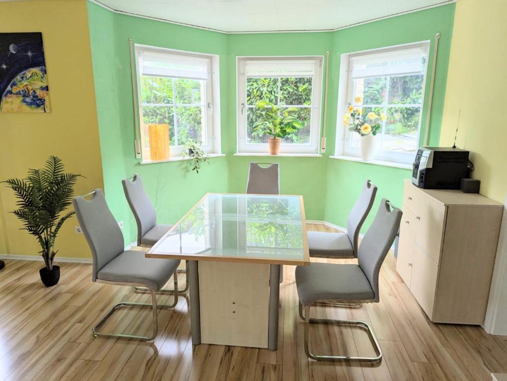 an office with a glass table and chairs and windows at Ferienwohnung Eifeltraum in Masburg