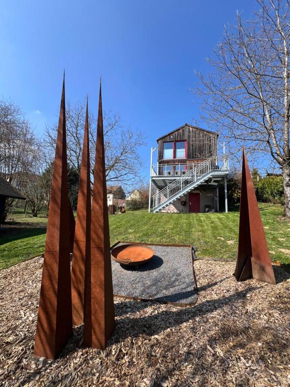 a sculpture of three wooden posts in a park at Künstlerhaus Vulkaneifel in Mückeln