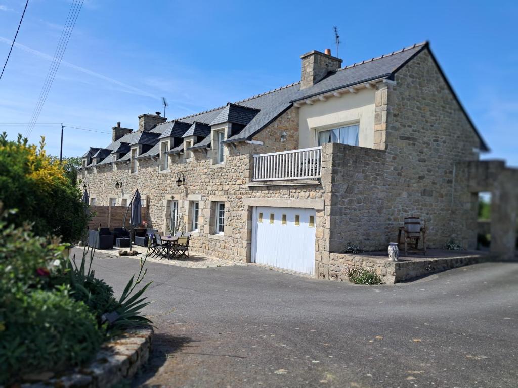 a brick house with solar panels on top of it at gîte en campagne Lamégritnière in Mégrit