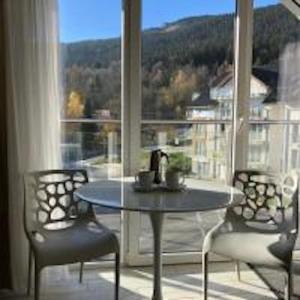 a table and chairs in front of a large window at Apartament studio Czarna Góra II in Sienna