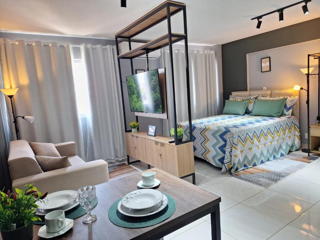 a large living room with a bed and a table at Studio Elegante - Completo - AC - Garagem in Rondonópolis