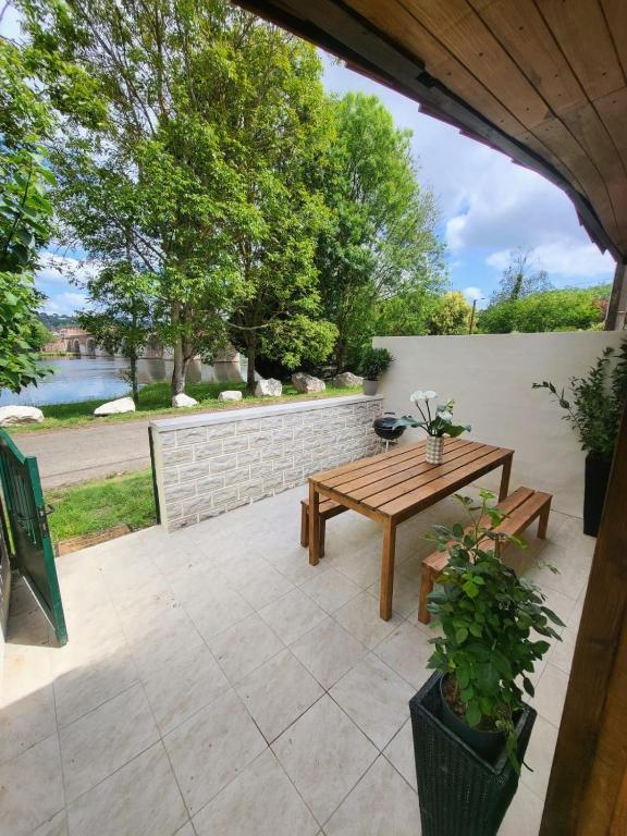 un patio con un tavolo di legno e una panca di Le Chalet de Moissac a Moissac