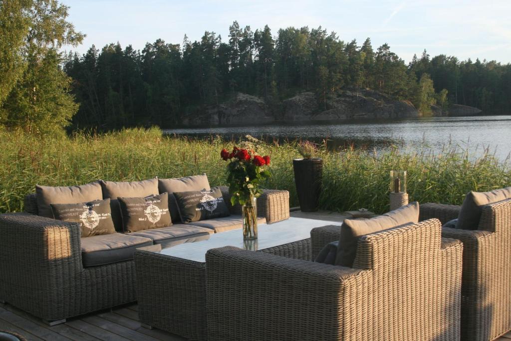 a patio with couches and a table with flowers at Kulla Gard in Ingarö