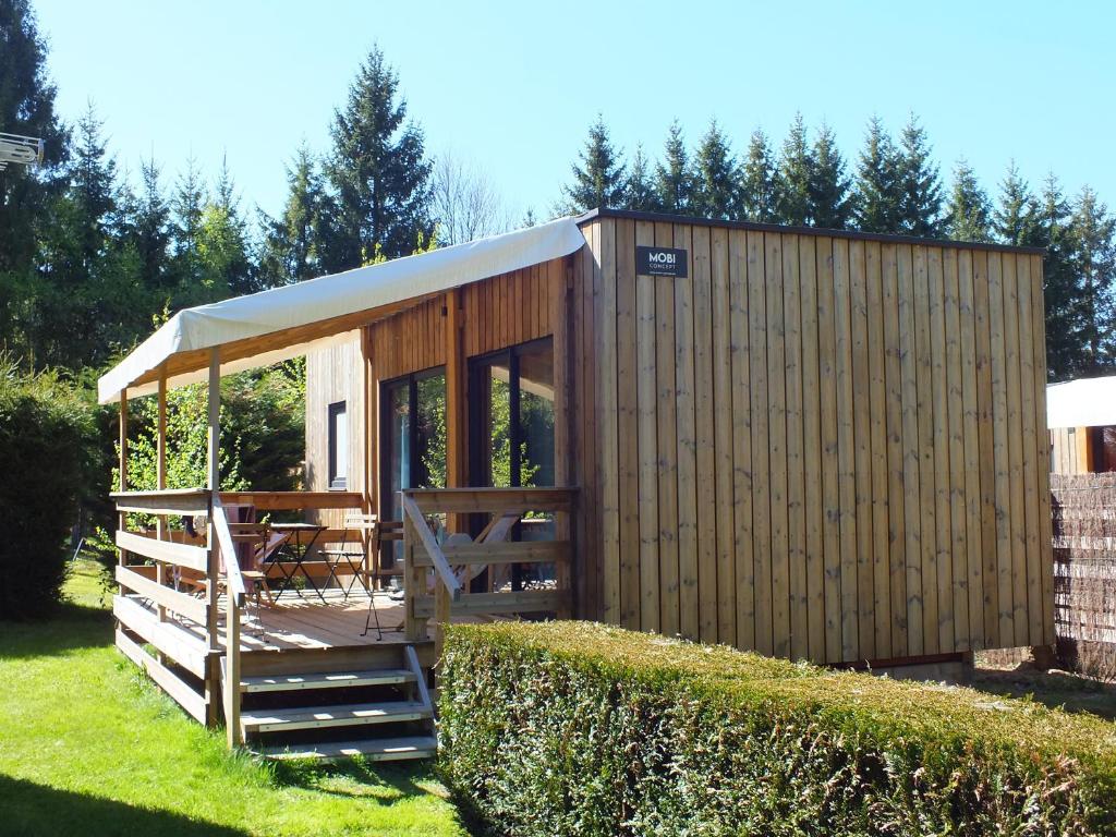 a small wooden cabin with a table in a yard at Tiny House - Cottages - Mobilhomes - Camping Les Granges Bas in Gérardmer