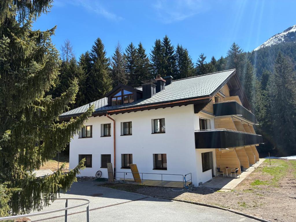 a large white building with a gambrel roof at Ferienwohnung Haus Ginseng in Davos