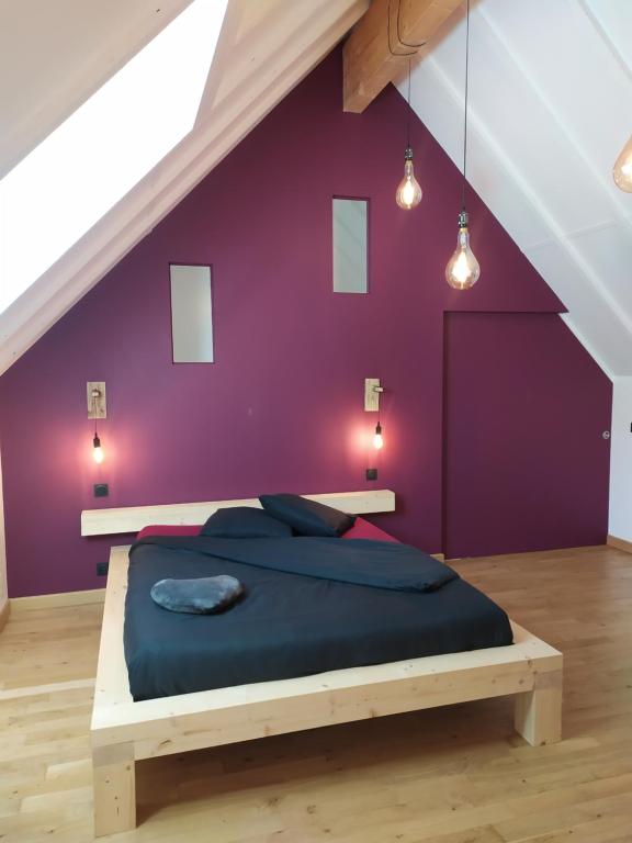 a bedroom with a purple wall and a bed at Calme et Volupté in Maxilly-sur-Saône