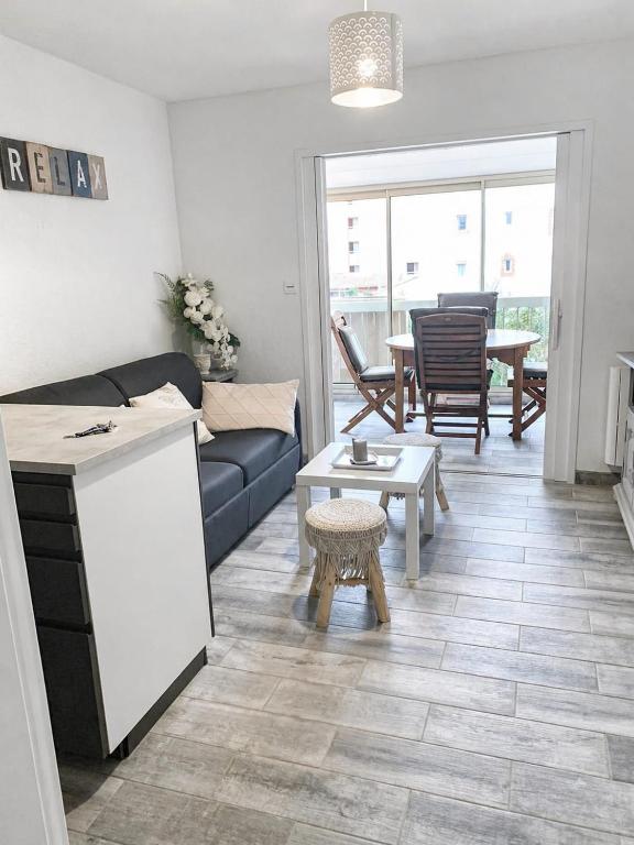a living room with a couch and a table at STUDIO REFAIT À NEUF BORD DE MER in Six-Fours-les-Plages