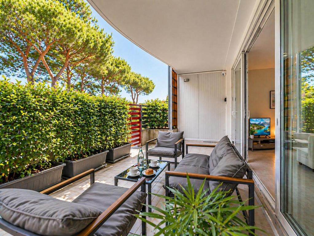 an outdoor patio with couches and a table at Vacanze Residence Mimose - con parcheggio relax tra pineta e spiaggia in Eraclea Mare