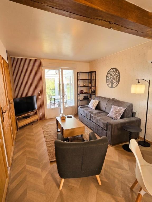 a living room with a couch and a table at Le passage, maisonnette cosy classée 4 étoiles in Pont-lʼÉvêque