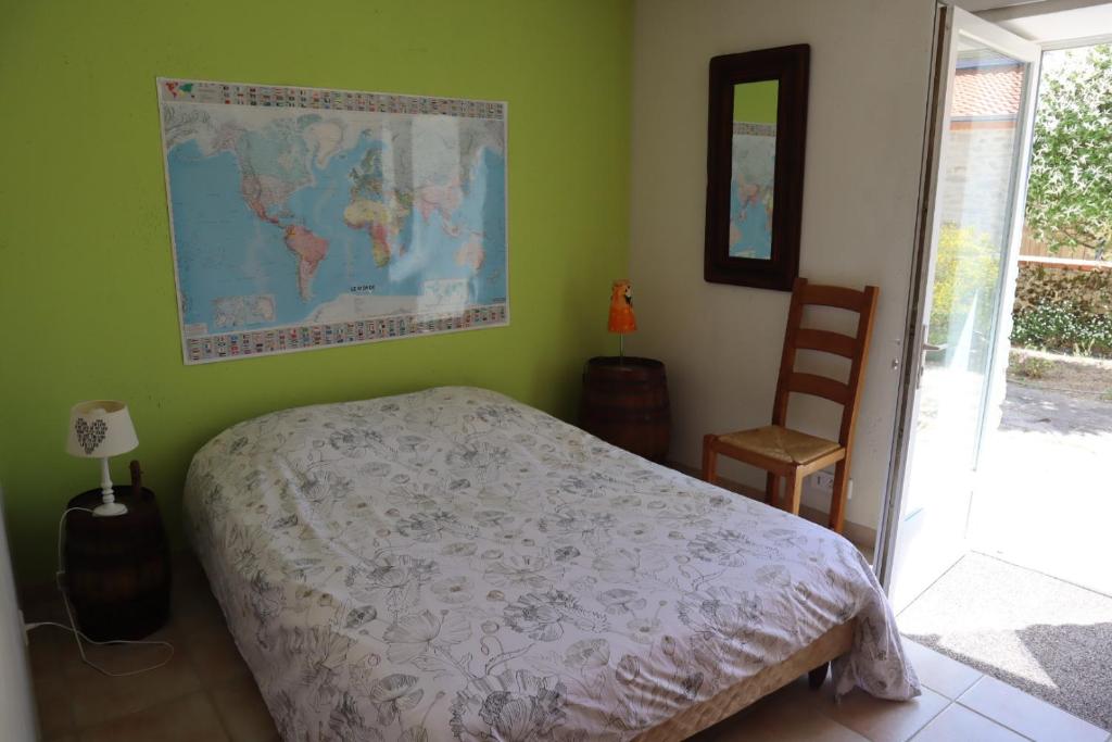 a bedroom with a bed and a map on the wall at Chambre, entrée indépendante, SDB privée in Cugand