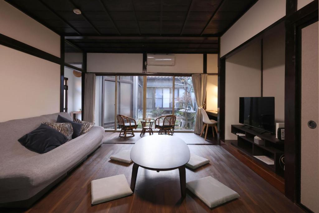 a living room with a couch and a table at 氷見のお宿むすびえ 旧やわや 1日1組1棟貸し in Himi