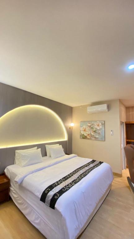 a bedroom with a large white bed in a room at Blessing Hotel Pandan in Halangan