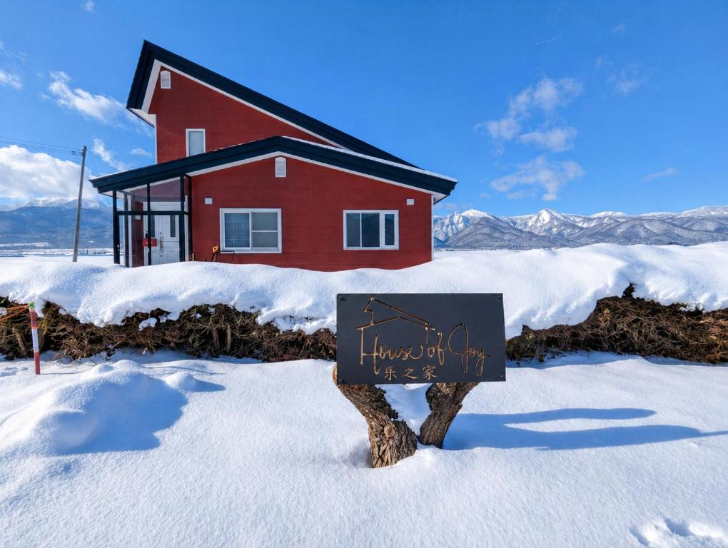 a sign in the snow in front of a house at House Of Joy Furano -15 mins to ski resort- in Furano