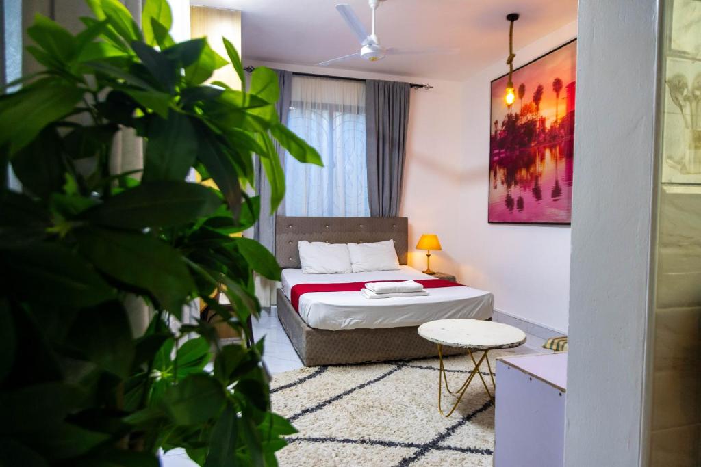 a bedroom with a bed and a potted plant at Artist sanctuary lakeview phase4 in Mto Panga