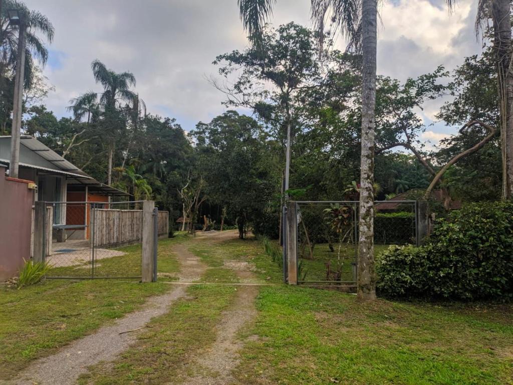 an open gate on a dirt road with trees at Condominio Vila Contanainer in Morretes
