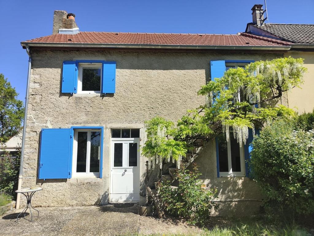 a house with blue shutters and a white door at Gîte du Tilleul in Beire-le-Châtel