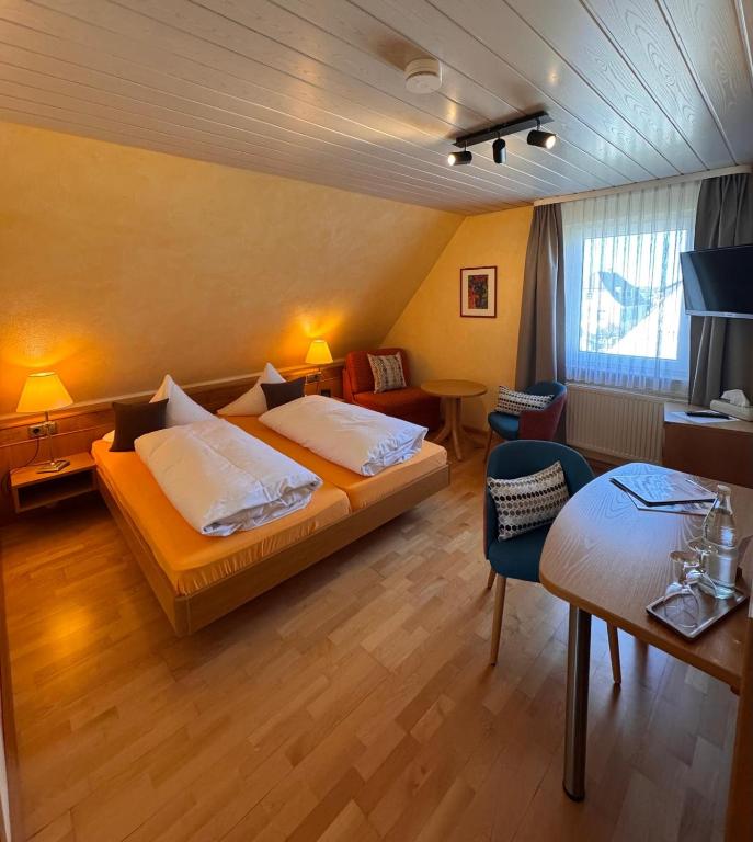a hotel room with a bed and a table at Hotel-Restaurant Gasthof Adler in Neuenburg am Rhein